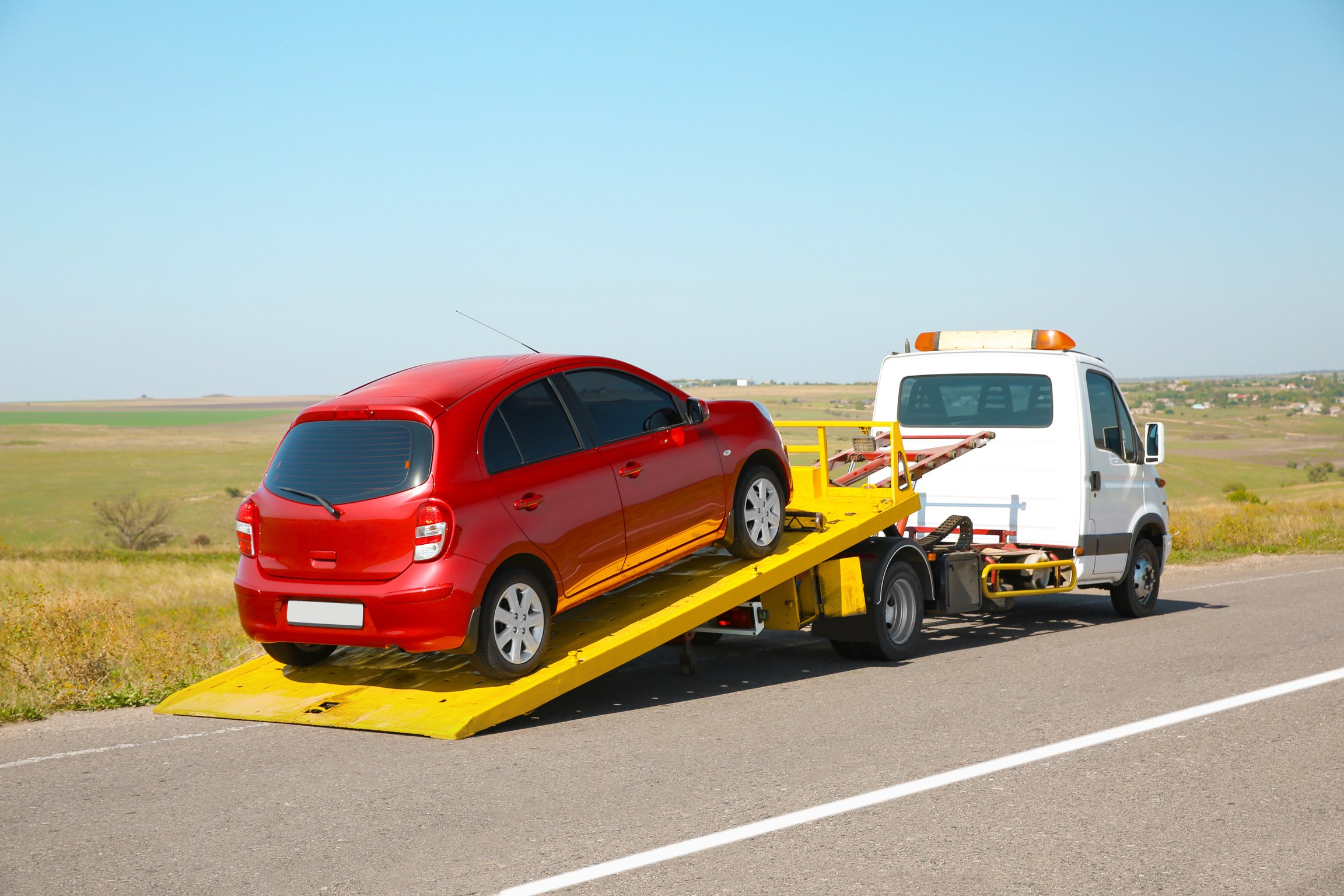 Tow Truck with Broken Car on Country Road